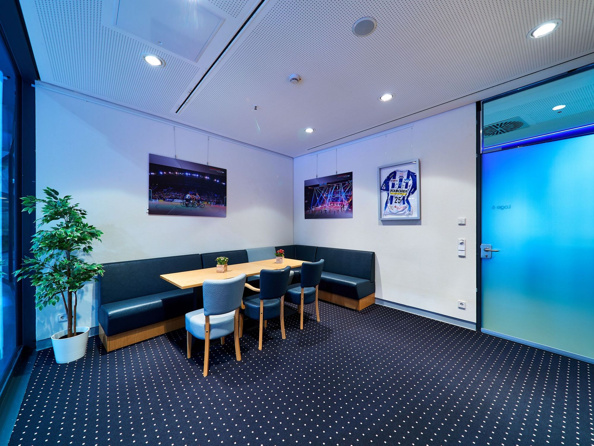 Blick in eine Loge mit schwarzem Teppich, schwarzem Sofa und einem Tisch.