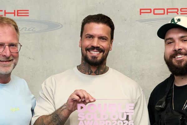 Gruppenfoto mit drei Personen, in der Mitte Emmvee, der den Award in den Händen hält. Links steht René Otterbein (in.Stuttgart Veranstaltungsgesellschaft), rechts Sascha Schmitz (Projektleiter Meyer-Konzerte).