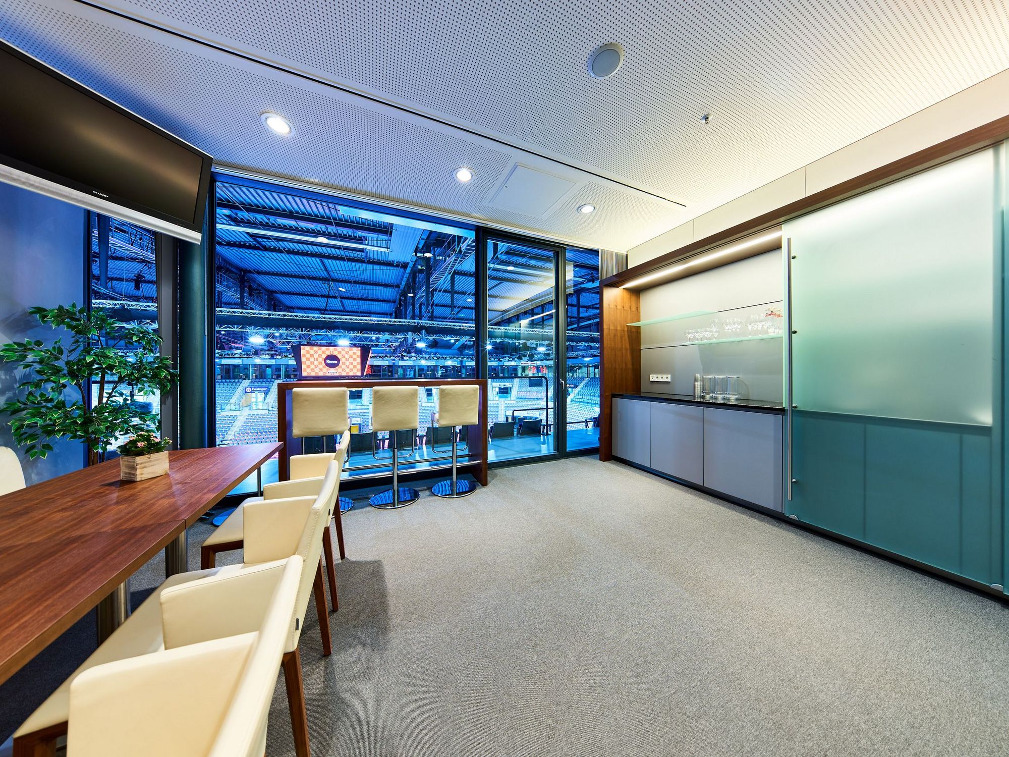 Blick auf den Thresen in einer Loge. Durch die großen Fenster kann man direkt in die Porsche-Arena und auf den Videowürfel sehen.