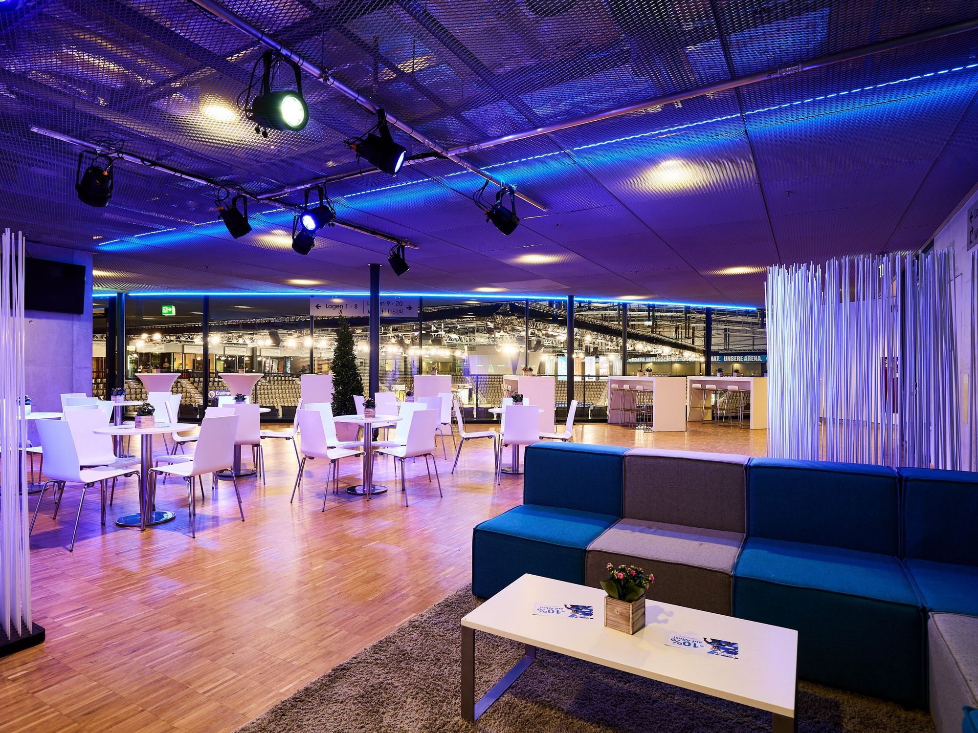 Blick von einer Couchgarnitur auf den Sitzbereich in der Hospitality der Porsche-Arena