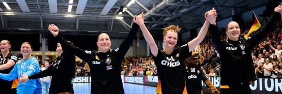 [Translate to Englisch:] Nationalspielerinnen halten sich an den Händen und halten diese in die Höhe. Große Freude in ihren Gesichtern.